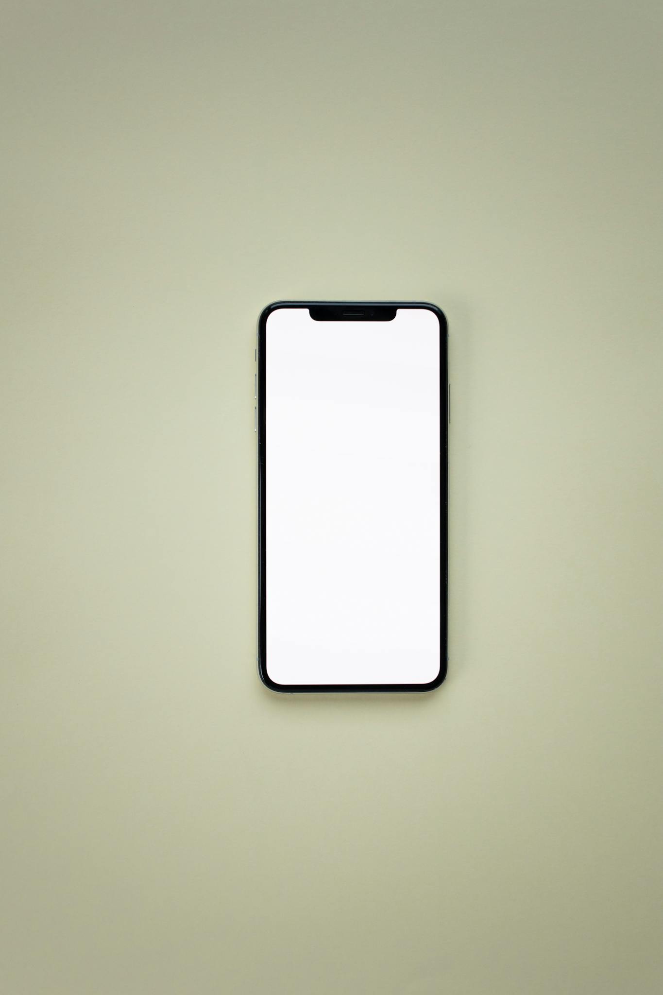 Smartphone with blank screen on neutral background for design mockup.
